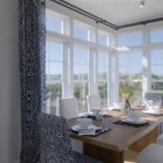 A bright dining room with large windows and a neatly set table.