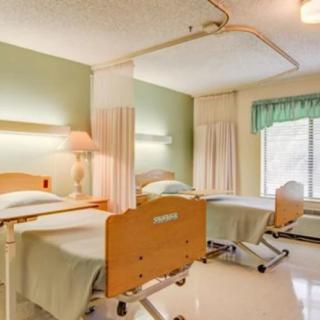 A hospital room with two beds separated by curtains.