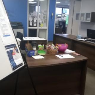 A well-organized office space featuring a reception area with various items on the desk.