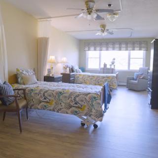 A well-lit, comfortable bedroom featuring two beds, a cozy seating area, and stylish decor.