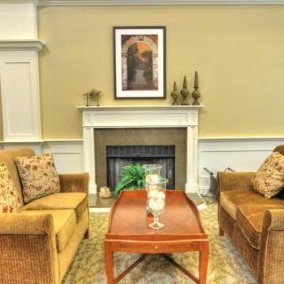 A cozy living room with two sofas facing each other and a fireplace in the center.