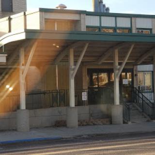 A modern building entrance with a covered walkway and stairs.
