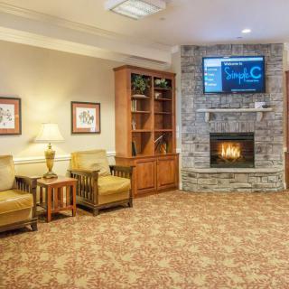 A cozy living room with a stone fireplace, television, and comfortable seating.