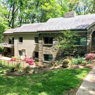 A stone house surrounded by lush greenery and a well-maintained garden.