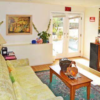 A cozy living room featuring a sofa, coffee table, various decor items, and artwork on the wall.