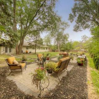 A serene patio area with comfortable seating surrounded by lush greenery.