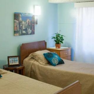 A cozy bedroom with twin beds, blue walls, and modern decor.