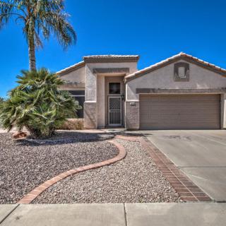 A suburban house with a dry landscape and palm tree, featuring a two-car garage and a clear blue sky.
