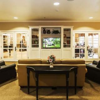 A modern living room with comfortable seating, a television, and elegant bookshelves.