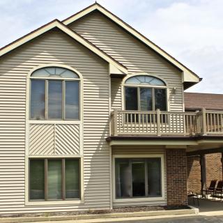 A two-story residential house with a balcony and large windows.