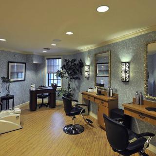 A modern, well-decorated hair salon interior with styling chairs and mirrors.
