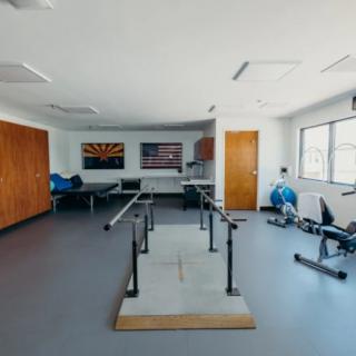 A spacious physical therapy room equipped with various rehabilitation tools and exercise equipment.
