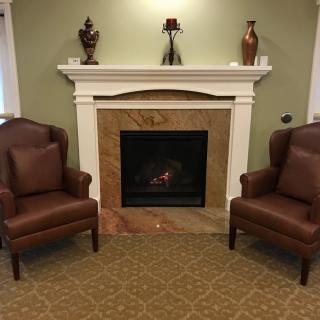 A cozy living room setup with two brown leather chairs flanking a fireplace.