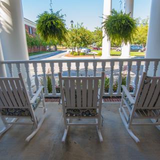 A cozy porch with rocking chairs overlooking a scenic view.