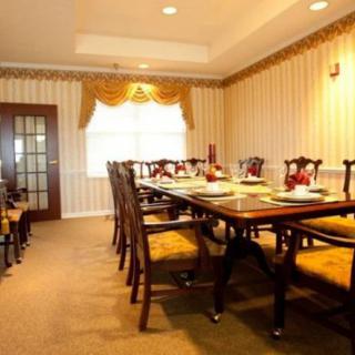 An elegant dining room with a long table and chairs, featuring classic decor.