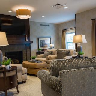 A cozy and elegantly furnished living room with comfortable seating and decorative lighting.