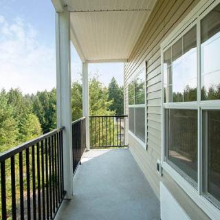 A serene balcony with a view of lush green trees.