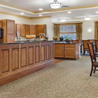 A spacious kitchen and dining area featuring wooden cabinets and elegant chandeliers.