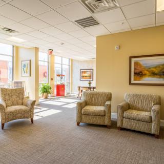 A well-lit waiting room with comfortable chairs and artwork on the walls.