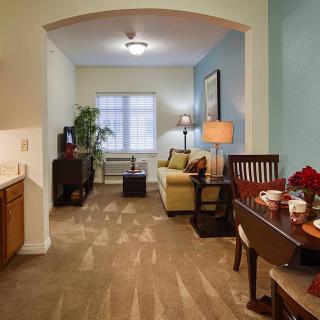 A cozy living and dining area with a sofa, television, and elegant decor.