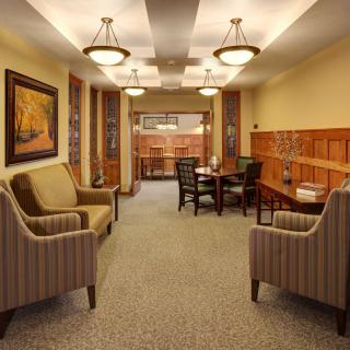 A cozy lounge area featuring armchairs, a table, and decorative lighting.