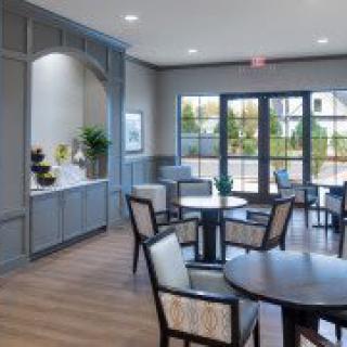 A modern dining area with stylish furniture and large windows.