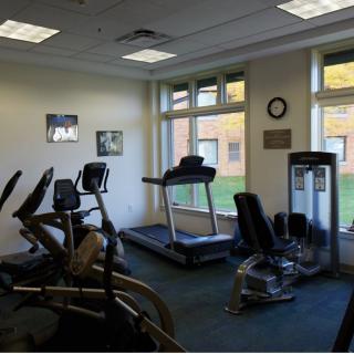 A small gym with cardio fitness equipment including treadmills and exercise bikes.
