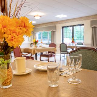 A cozy and inviting dining area featuring a floral centerpiece and elegant table settings.