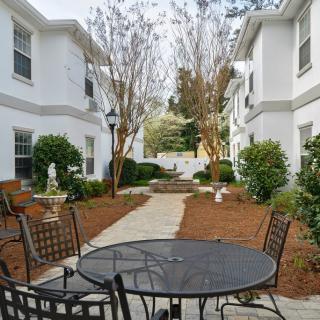 A well-maintained courtyard with outdoor seating between apartment buildings.