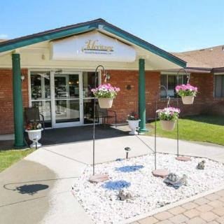 A well-maintained building entrance with hanging flower baskets and landscaped garden.