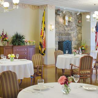 A well-appointed dining room with elegantly set tables and floral centerpieces.