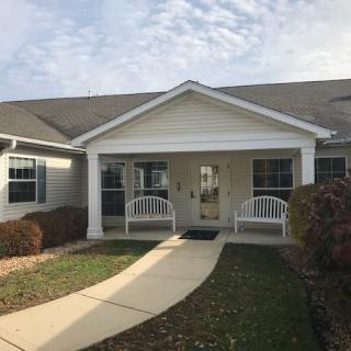 A welcoming suburban house with a front porch and pathway leading to the entrance.