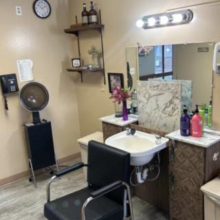 A cozy hair salon setup with a styling chair, mirror, and hairdryer.