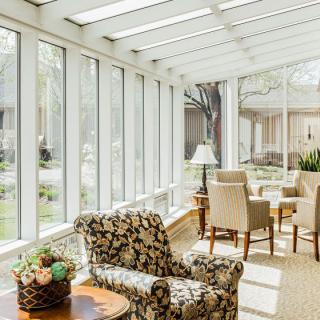 A bright and cozy sunroom with comfortable seating and ample natural light.
