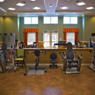 A spacious gym with various fitness equipment and bright lighting.