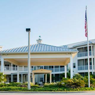 A modern hospital facility with an American flag in front.