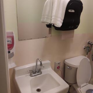 A compact bathroom setting featuring a sink, toilet, and towel.
