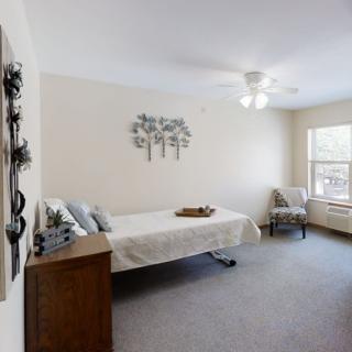 A minimalist bedroom with simple decor and a large window.