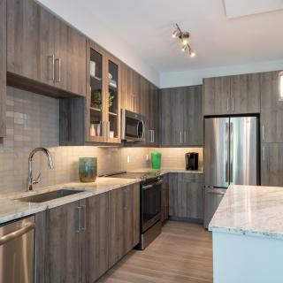Modern kitchen with wood cabinets and stainless steel appliances.