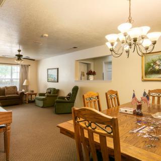 A cozy interior featuring a dining area with a chandelier and a comfortable living room.