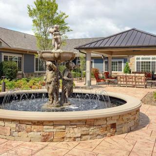 A beautifully designed outdoor space featuring a decorative fountain surrounded by landscaped gardens.