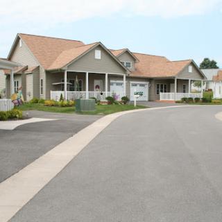 A charming suburban house with a well-maintained landscape and a curved driveway.