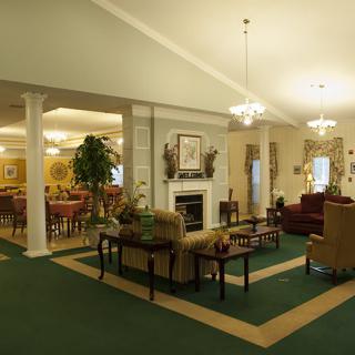 A cozy interior space with a fireplace, comfortable seating, and elegant chandeliers.