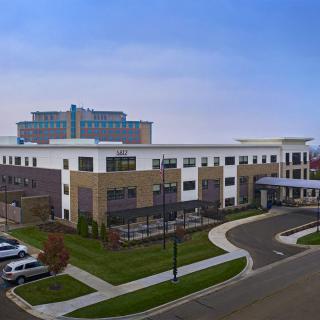A modern office building with a surrounding parking area and landscaped grounds.