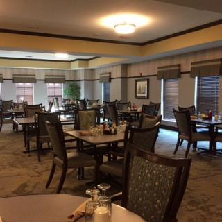 An empty dining room with neatly arranged tables and chairs.