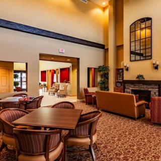 A hotel lobby with comfortable seating, a fireplace, and high ceilings.