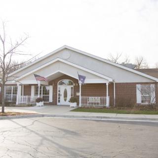 A small building with flags on display at the entrance during daytime.