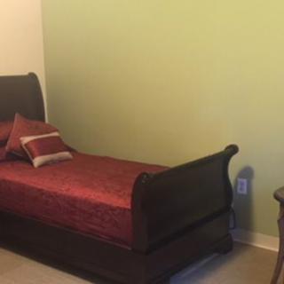 A neatly arranged bedroom with a single bed and simple decor.