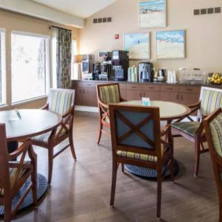 A cozy cafe seating area with tables, chairs, and a coffee station.