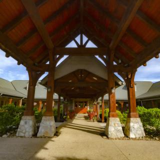 A grand wooden entrance with a covered walkway and decorative columns.